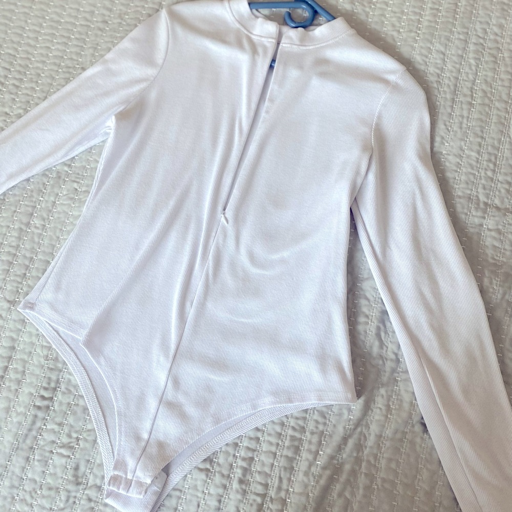 Selling a white long sleeve bodysuit shirt with zipper down the middle front.